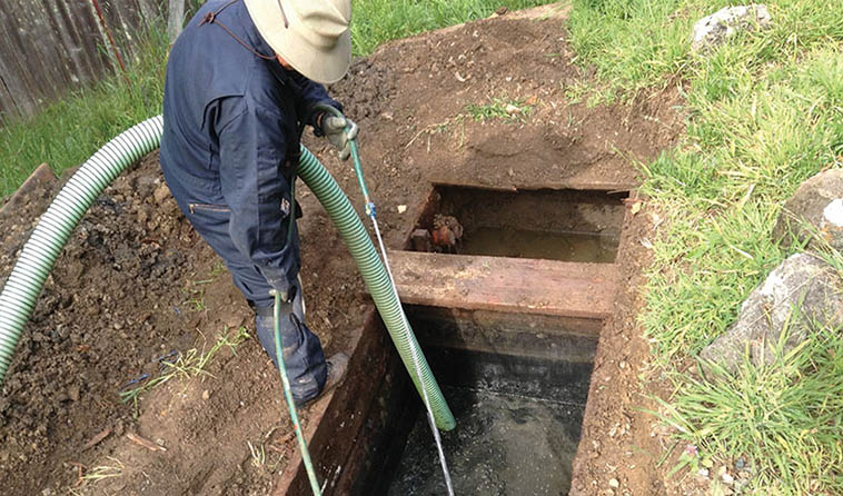 A man cleaning and unblocking a drainage